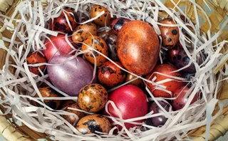 Chicken and quail eggs covered in metallic paint in a basket