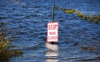 Sign saying ‘stop, road closed’ submerged in floodwater