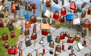 colourful padlocks locked to a wire fence