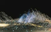 A dynamic abstract visualisation of glowing fibre-optic strands and light trails against a dark background, representing data flow, digital connectivity and high-speed network technology.