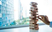 A Jenga game, and someone is pulling one of the wooden blocks out