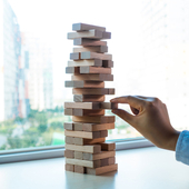 A Jenga game, and someone is pulling one of the wooden blocks out