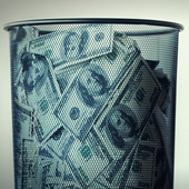US dollars in a wastepaper basket