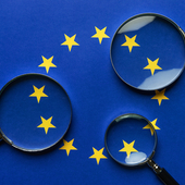 Three magnifying glasses scrutinise the EU flag