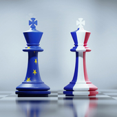 Two king chess pieces textured with French and European Union flags on black and white chessboard.