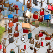 colourful padlocks locked to a wire fence