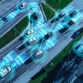 Aerial view of cars self-driving using AI, with computer representation of sensors emanating from the cars